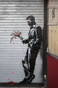 NEW YORK, NY - OCTOBER 24:  Graffiti by British street artist Banksy is seen on a roll-down security gate covering the main entrance to Larry Flint's Hustler Club on October 24, 2013 in the Hell's Kitchen neighborhood of New York City. On Banksy's website a caption for the work reads, "Waiting in vain...at the door of the club."  (Photo by John Moore/Getty Images)